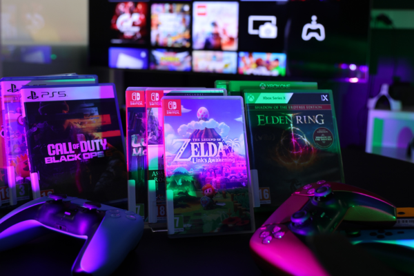 bilde av legend of zelda og andre spill til playstation, switch og Xbox i forgrunn. En TV i bakgrunnen